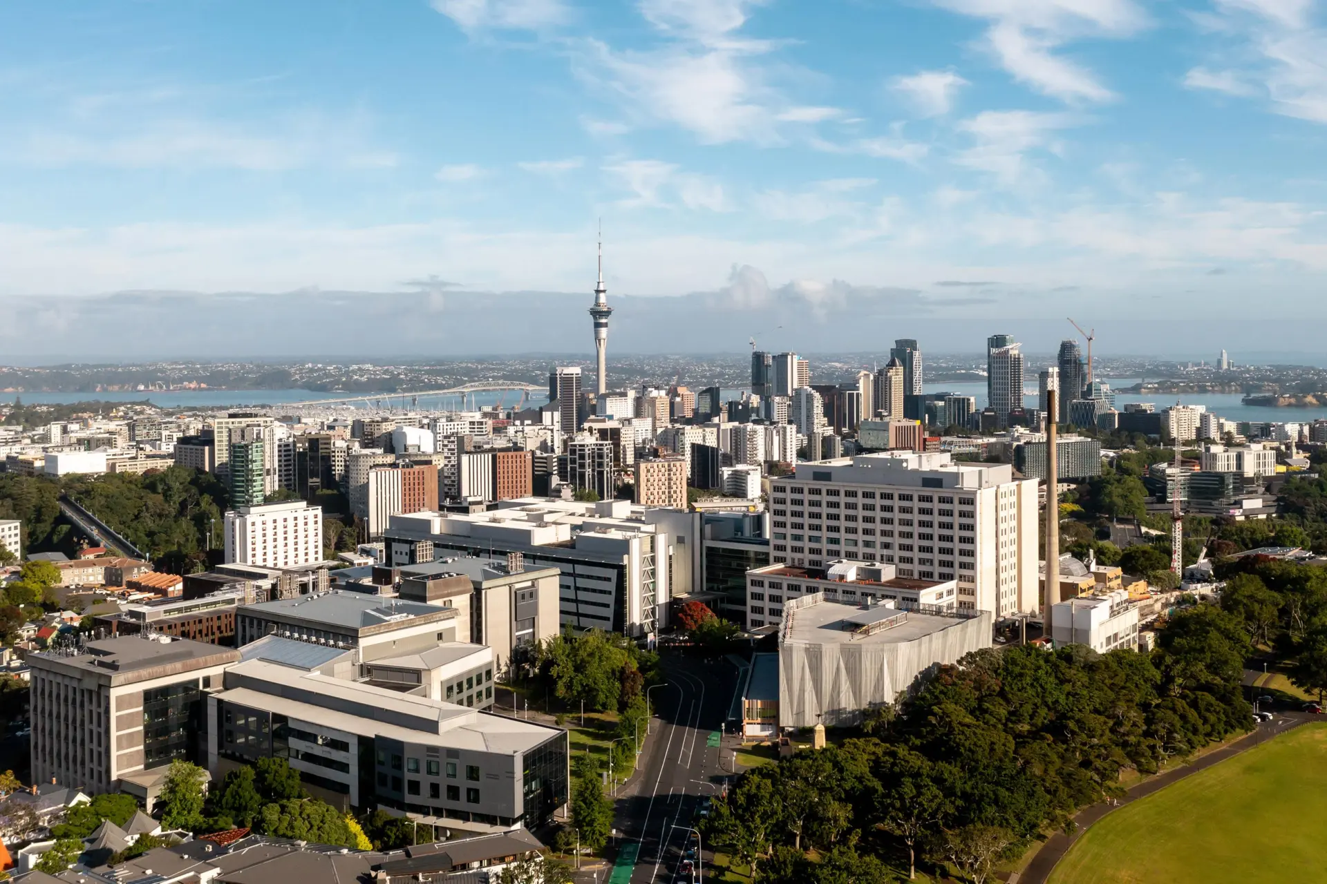 Aerial view of Auckland city centre, looking across a precinct of buildings towards the Sky Tower and the harbour.